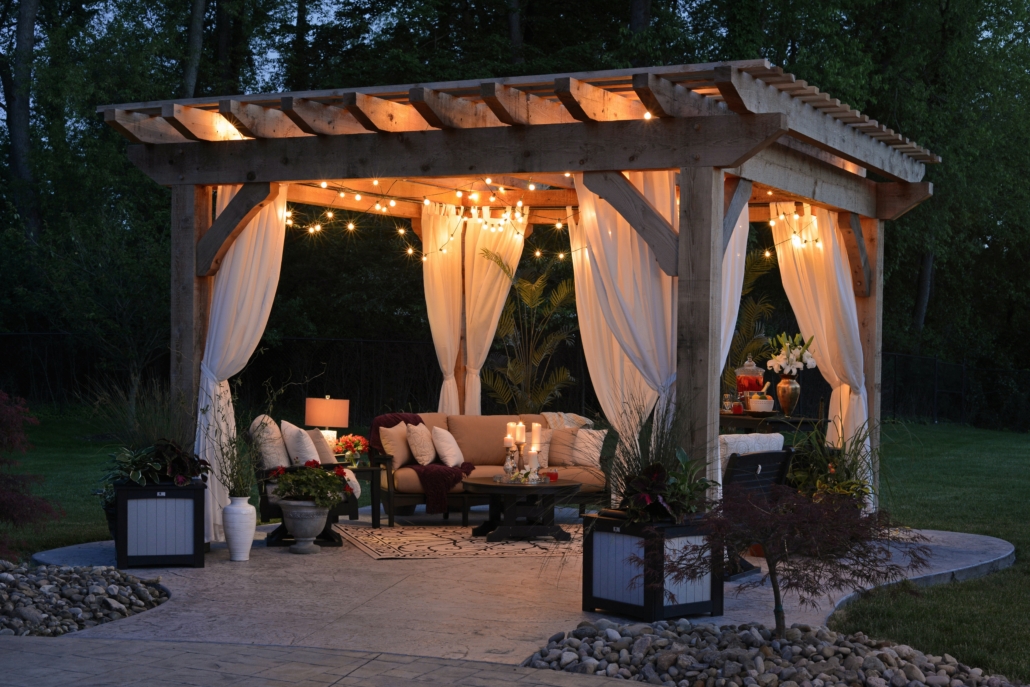 A gazebo at night time with soft lighting and curtains